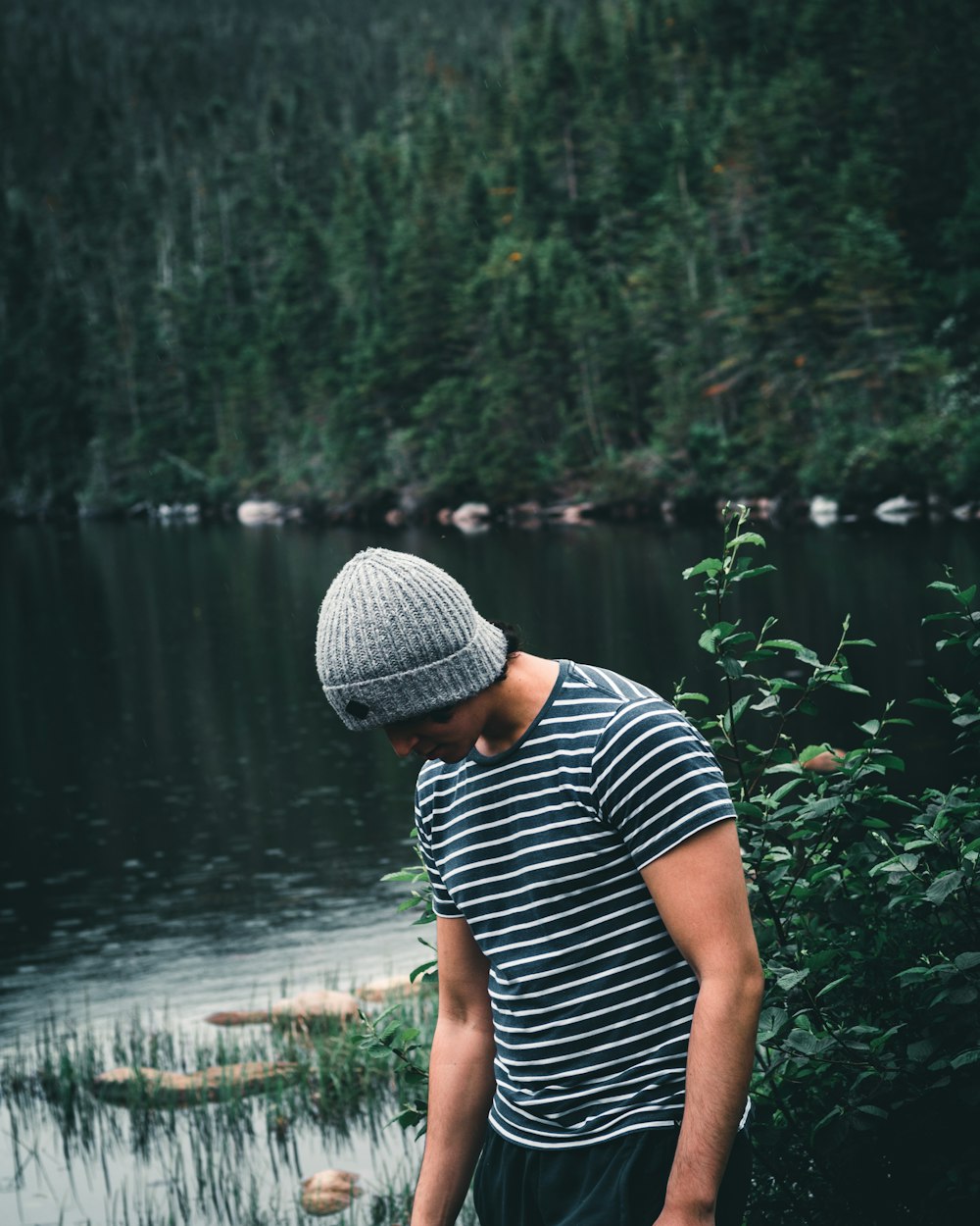 woman in black and white stripe shirt standing near lake during daytime