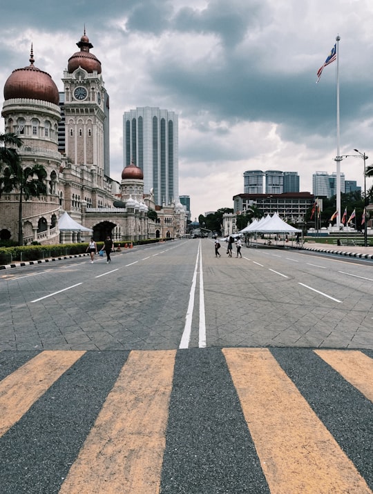 people walking on pedestrian lane near high rise buildings during daytime in Merdeka Square Malaysia