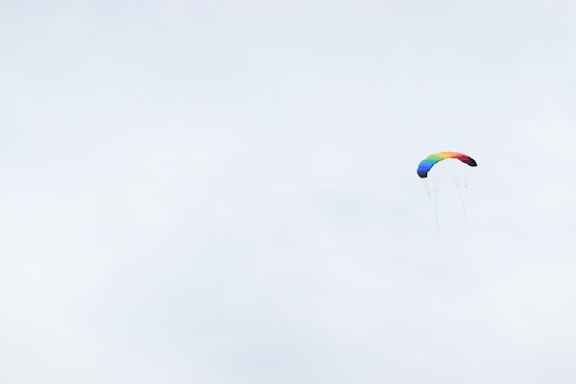 Colorful playful parachute with children holding edges outdoors on a sunny day