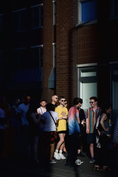 A group of friends wearing Jam Ras apparel, standing together in a sunlit urban setting.