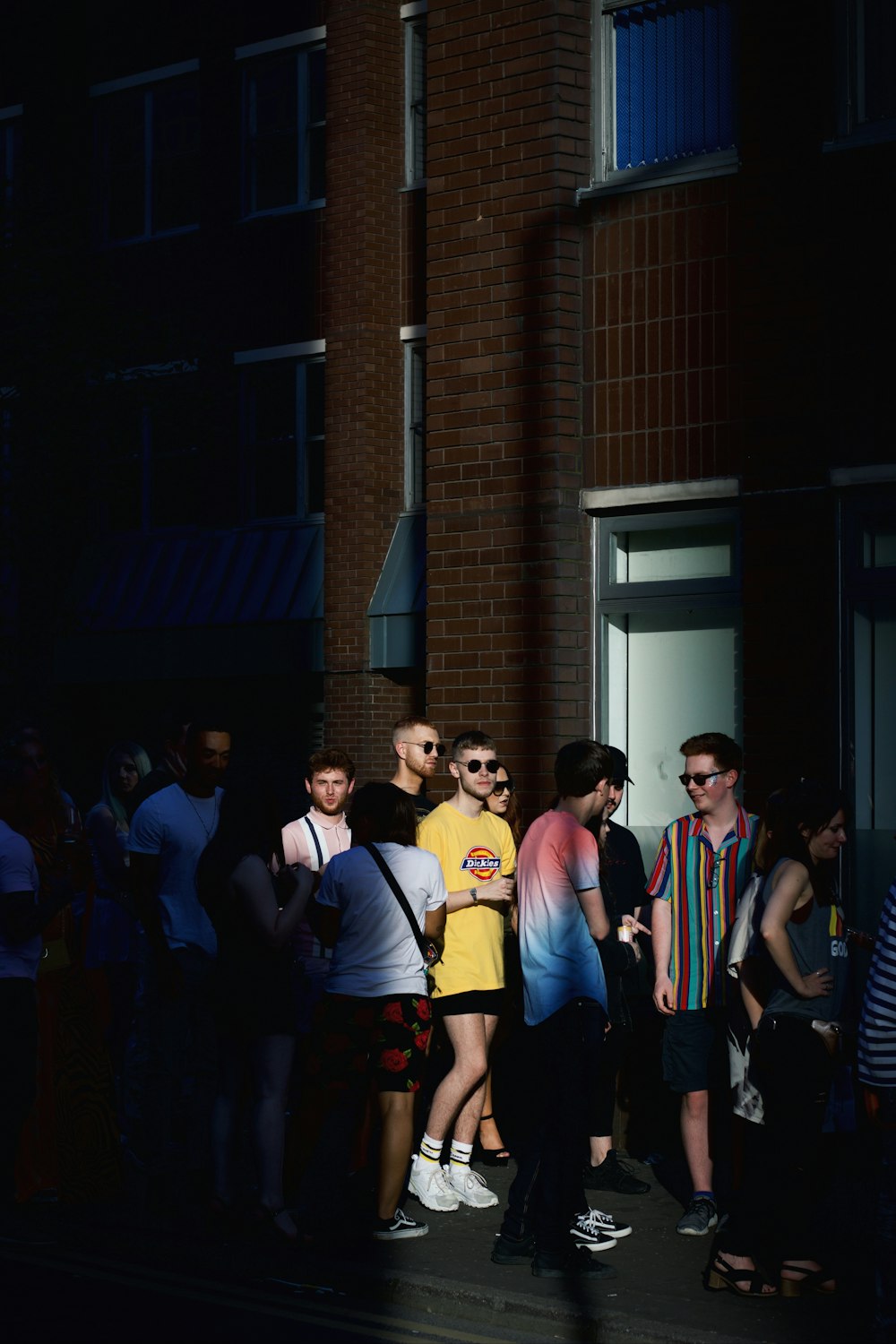 people standing in front of brown brick building during nighttime