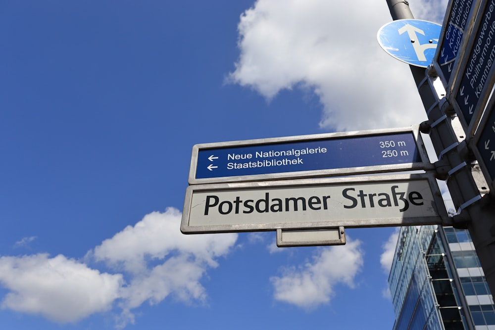 blau-weißes Straßenschild unter blauem Himmel