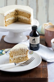 black glass bottle beside white ceramic plate with bread