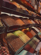 Colorful spices neatly arranged in traditional containers, showcasing rich textures.