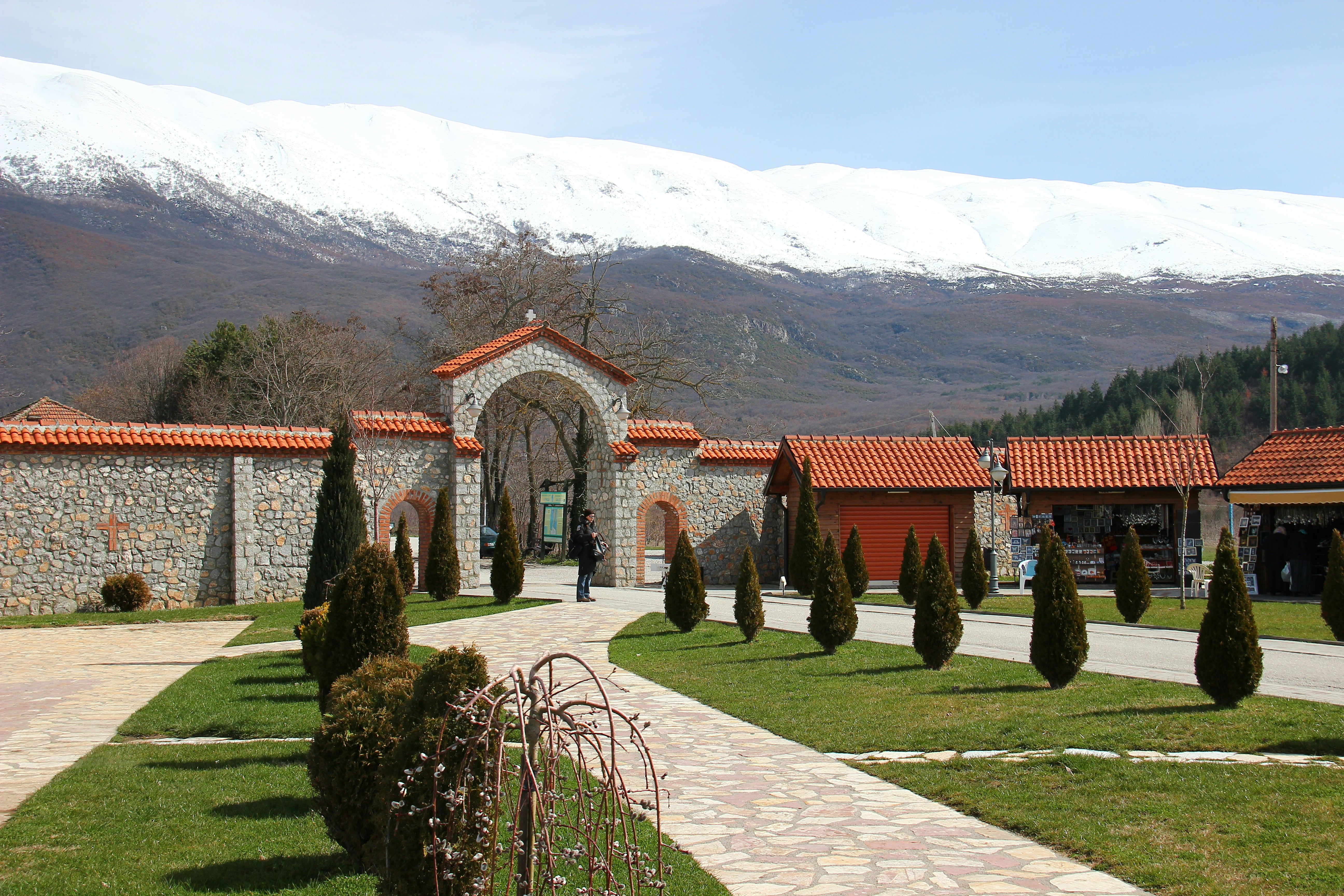 brown brick building near green grass field and mountain during daytime