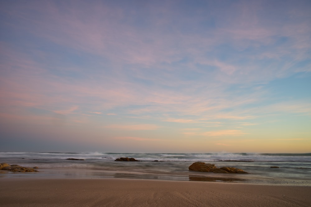 brown sand beach during sunset