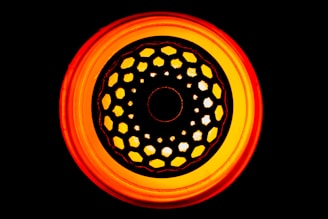 A warm crimson circular button with a delicate glass-morphism effect.