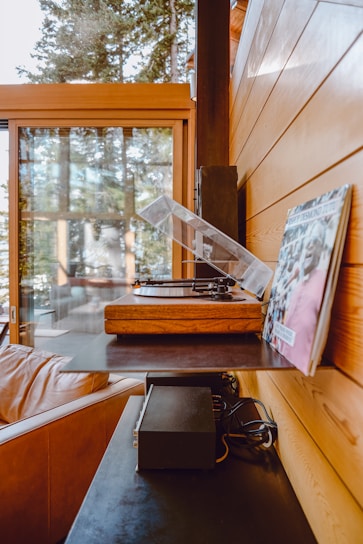 A cozy living room with vinyl records displayed on a shelf and a comfortable chair.