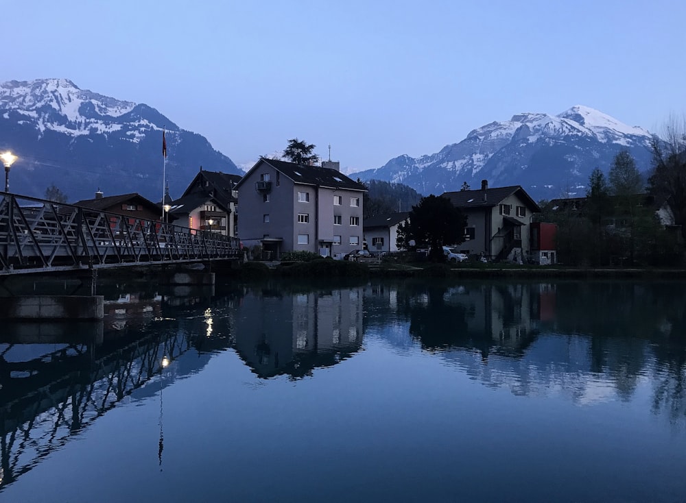 houses near lake and mountains during daytime