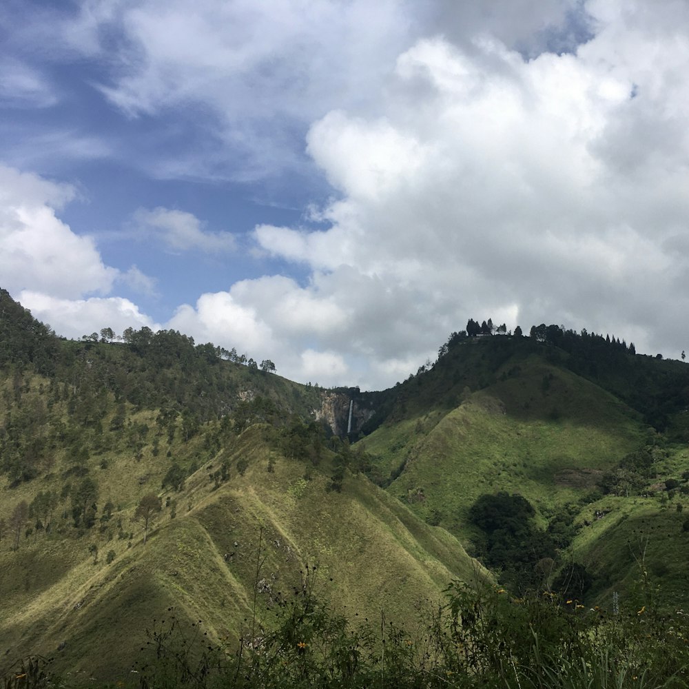 green mountain under white clouds during daytime