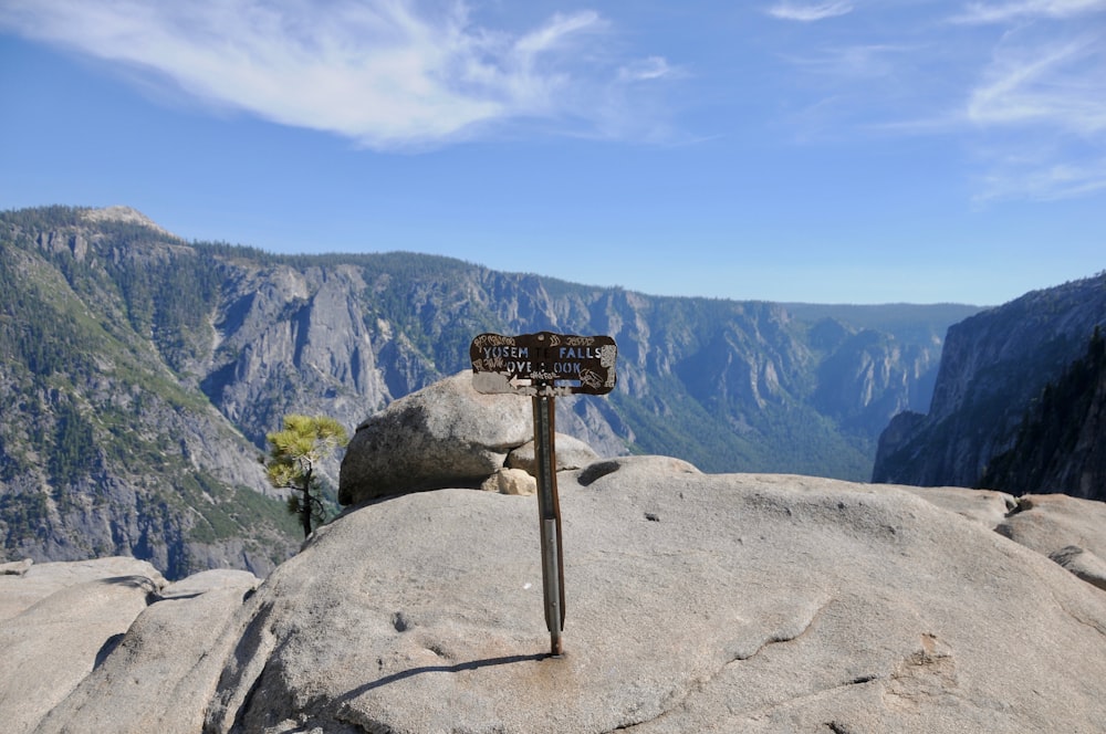 brown wooden cross on brown rock mountain under blue sky during daytime