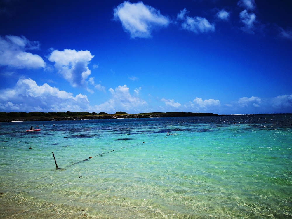 blue sea under blue sky and white clouds during daytime