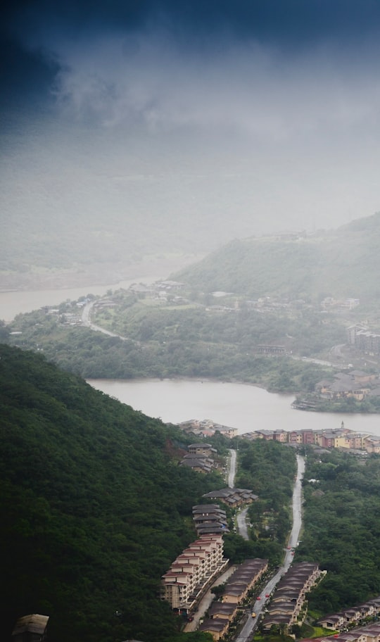 aerial view of city buildings on green mountain during daytime in Lavasa India