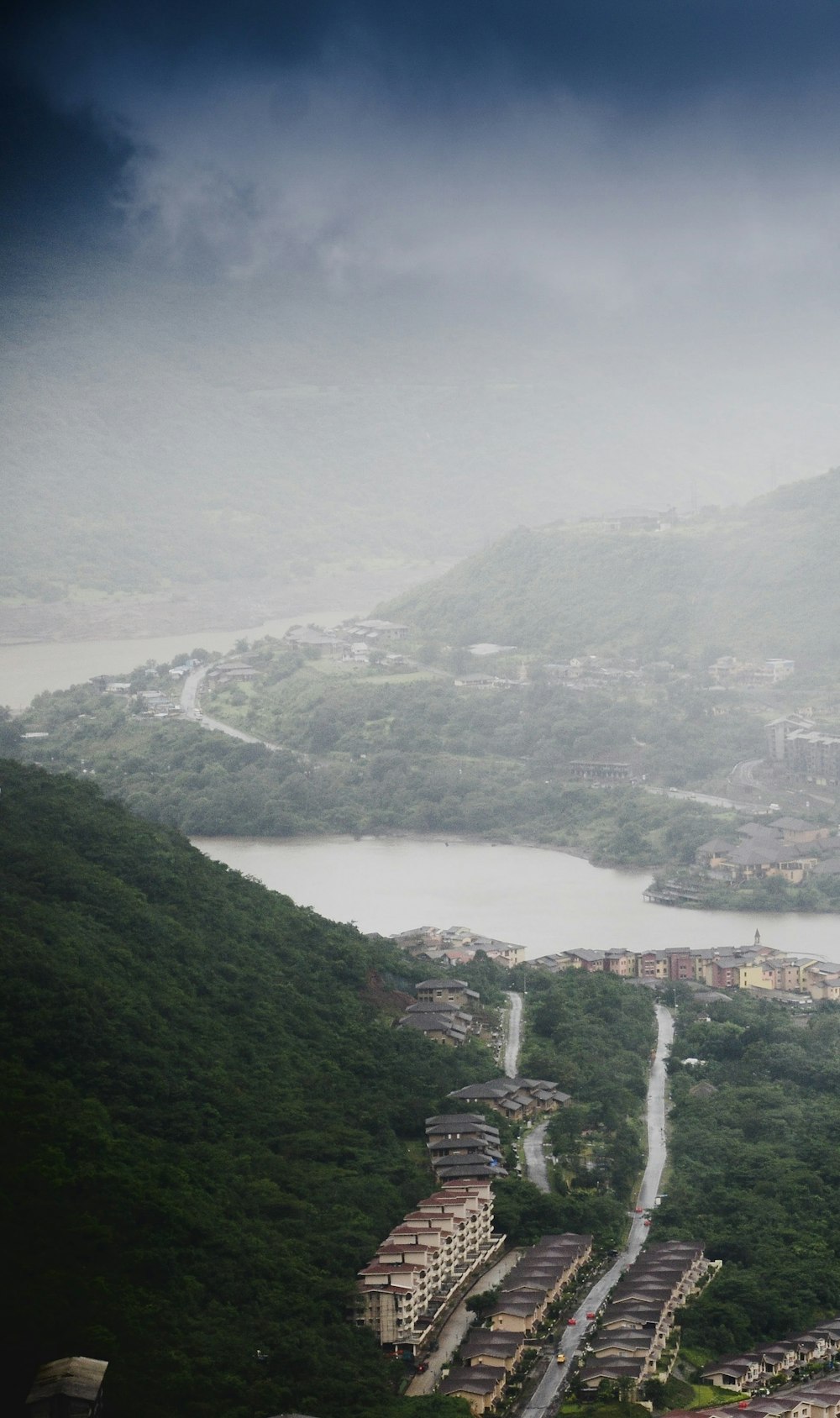 aerial view of city buildings on green mountain during daytime