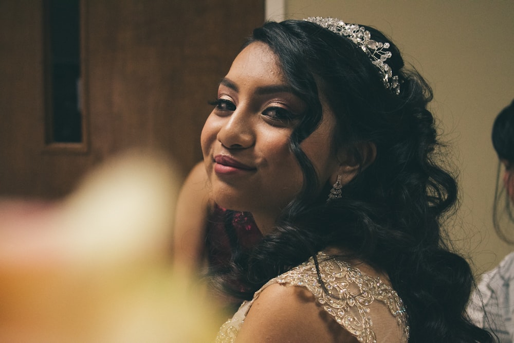 a woman wearing a tiara sitting at a table