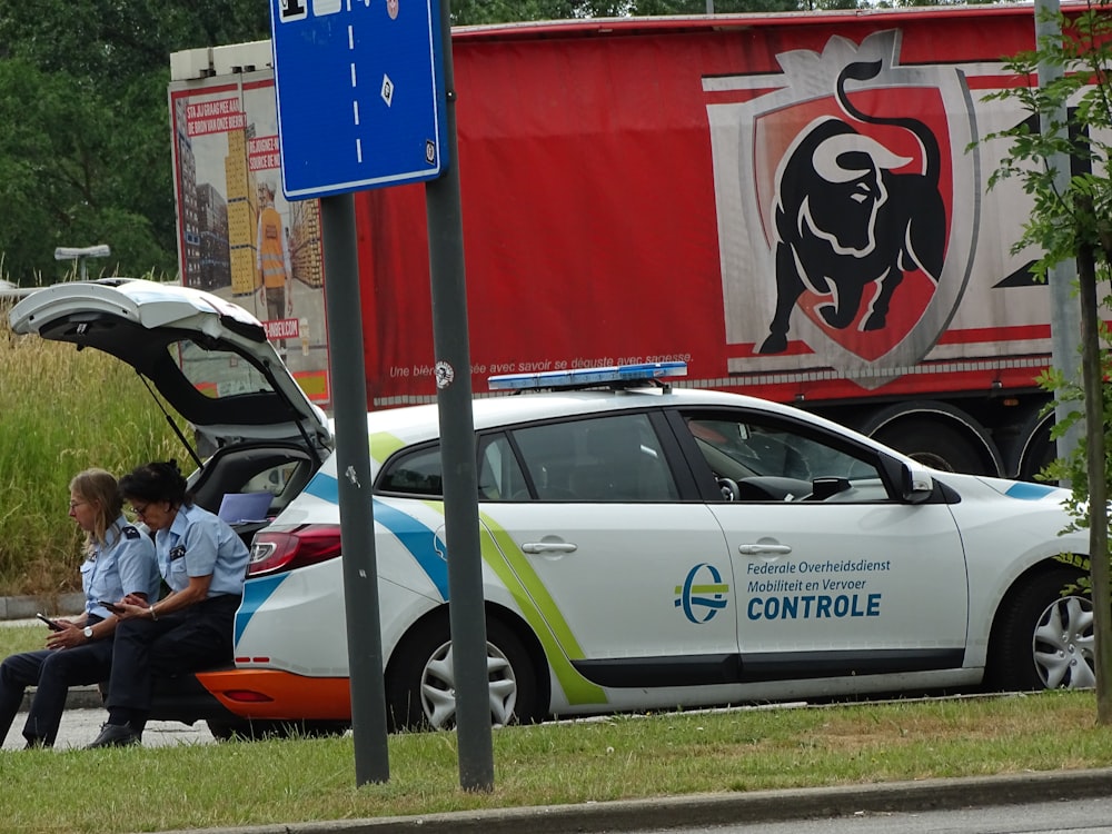 man in black jacket sitting on white car