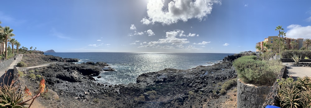 rocky shore under blue sky and white clouds during daytime