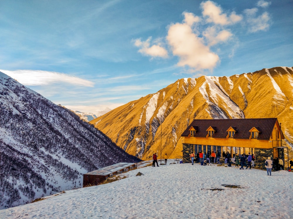 people walking on snow covered ground near mountain during daytime