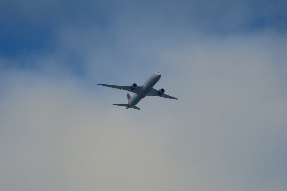 white airplane flying in the sky during daytime