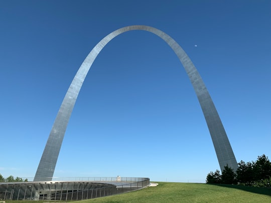 white metal arch under blue sky during daytime in The Gateway Arch United States