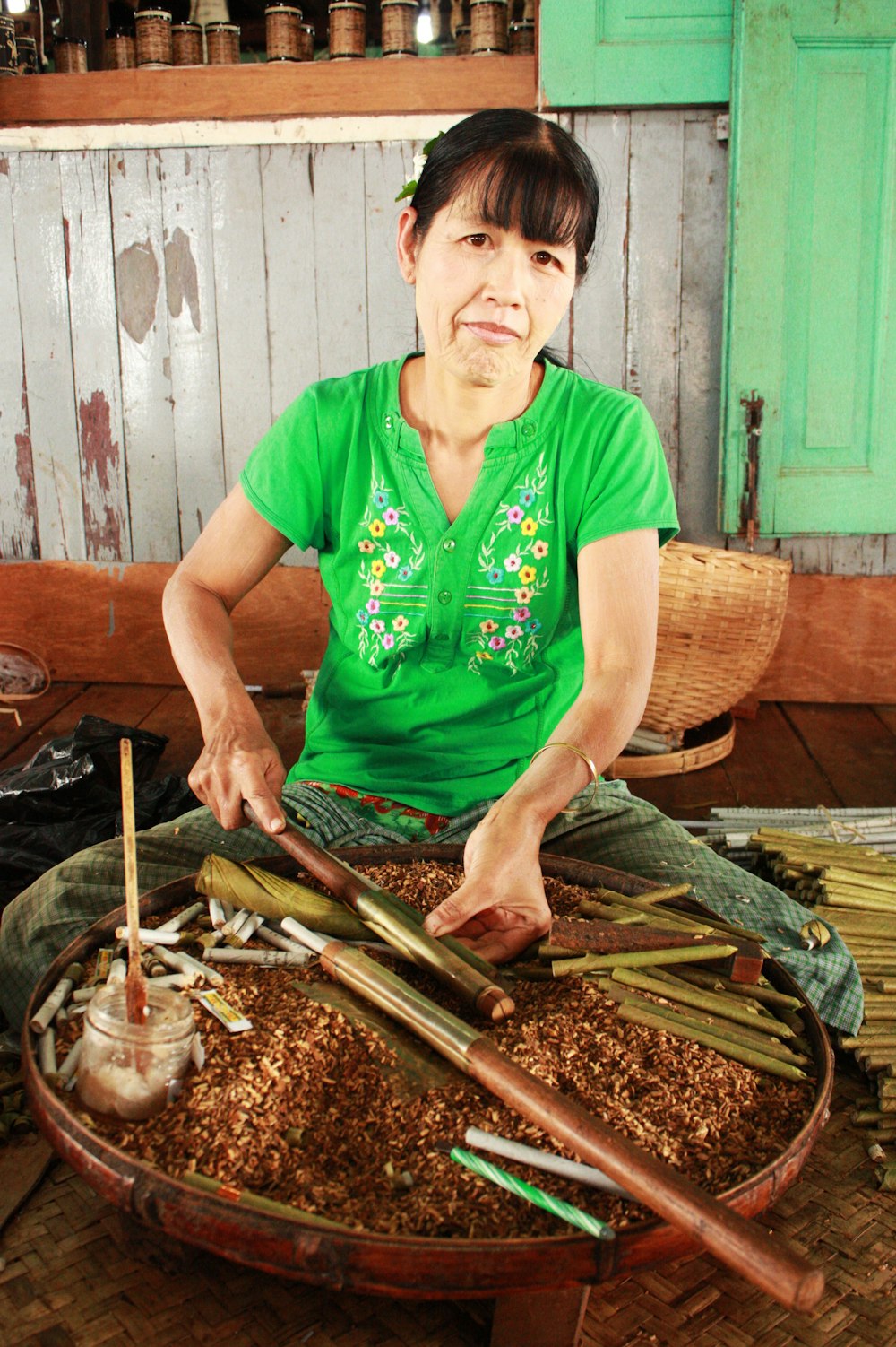 man in green v neck t-shirt holding brown wooden stick