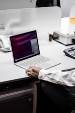 person in black blazer using macbook pro