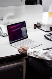 person in black blazer using macbook pro