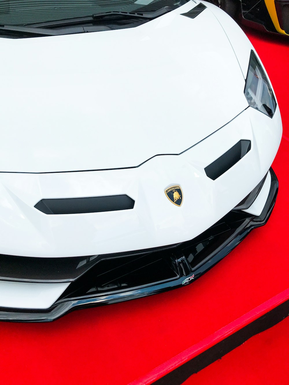 Lamborghini Aventador blanche sur textile rouge