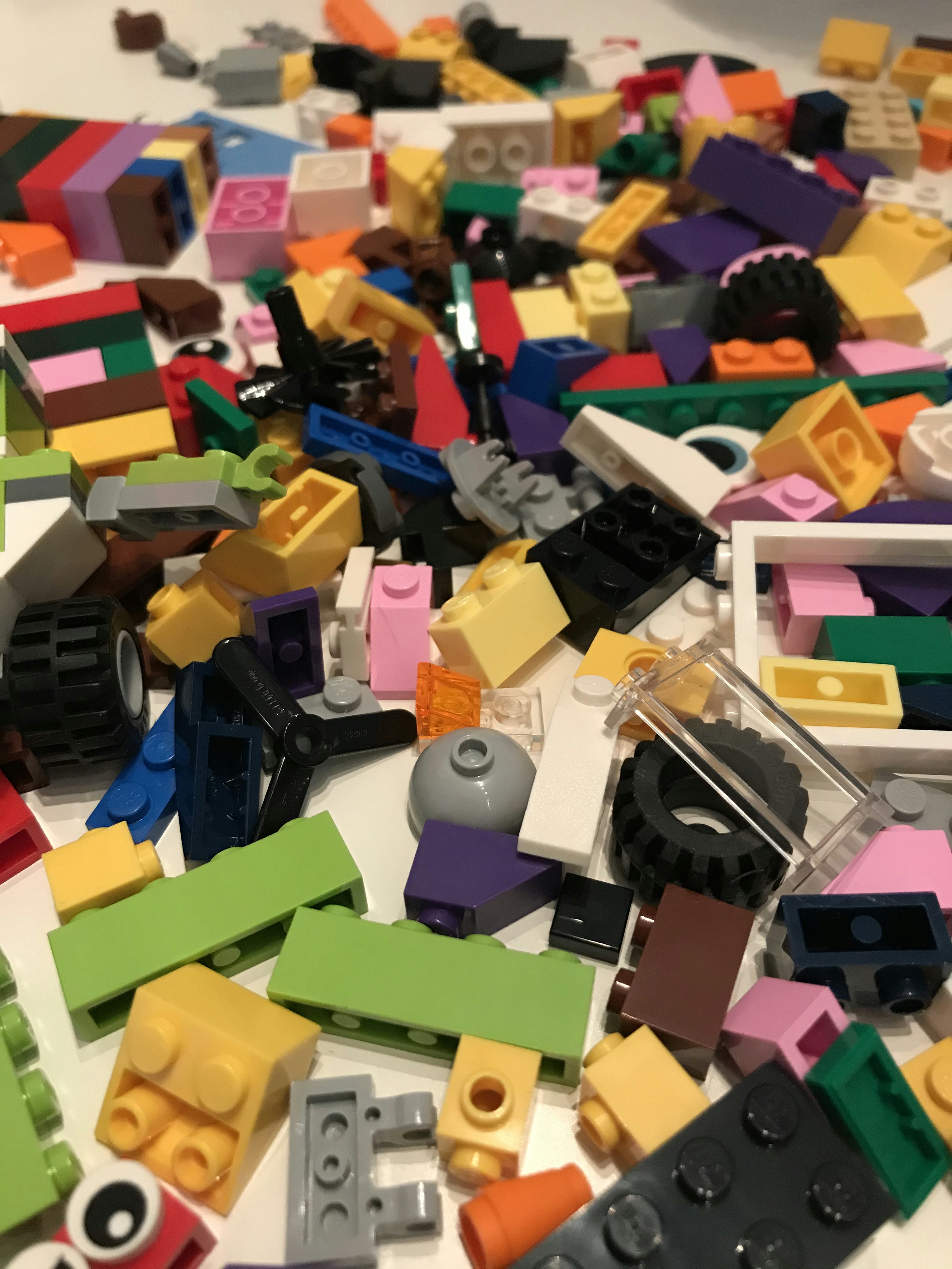 Colorful toys and building blocks scattered on bright white floor, playful setting