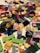 A colorful assortment of various Lego pieces scattered on a surface, including blocks, wheels, and connectors in a variety of shapes and sizes.