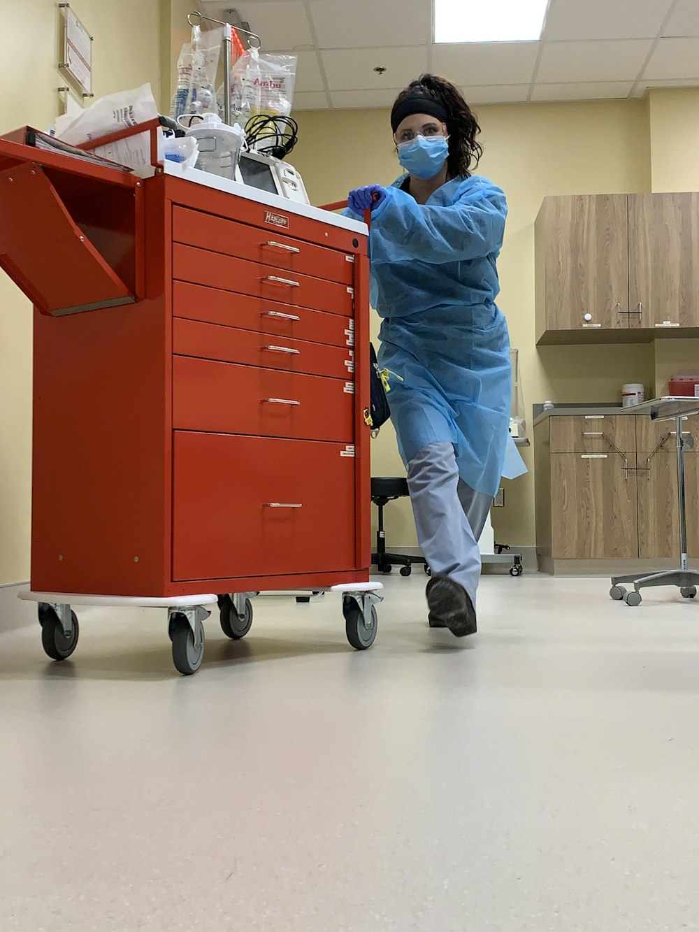 man in blue dress shirt and gray pants standing beside red cabinet