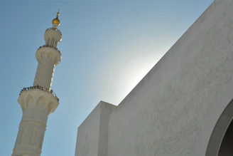 A shining minaret alem freshly polished, reflecting sunlight with a clear sky background.