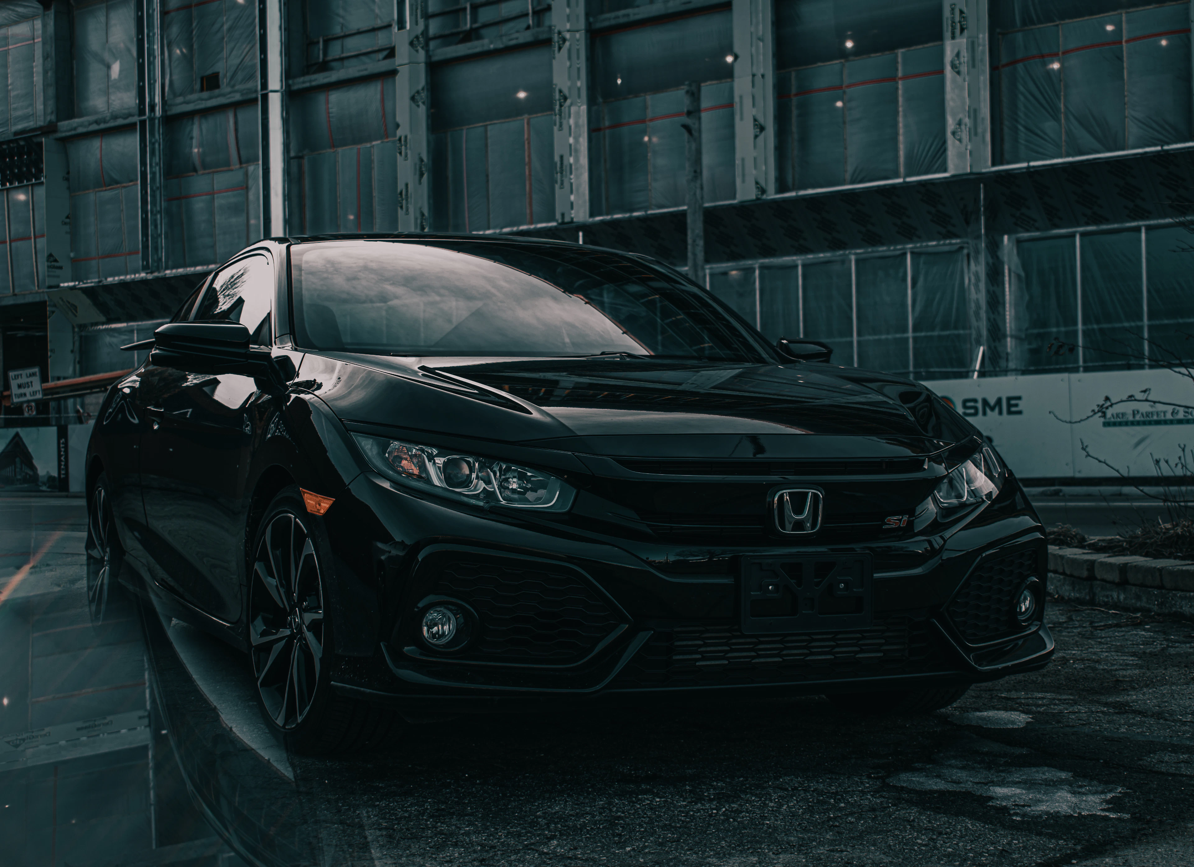 Black Honda Civic parked in front of a building