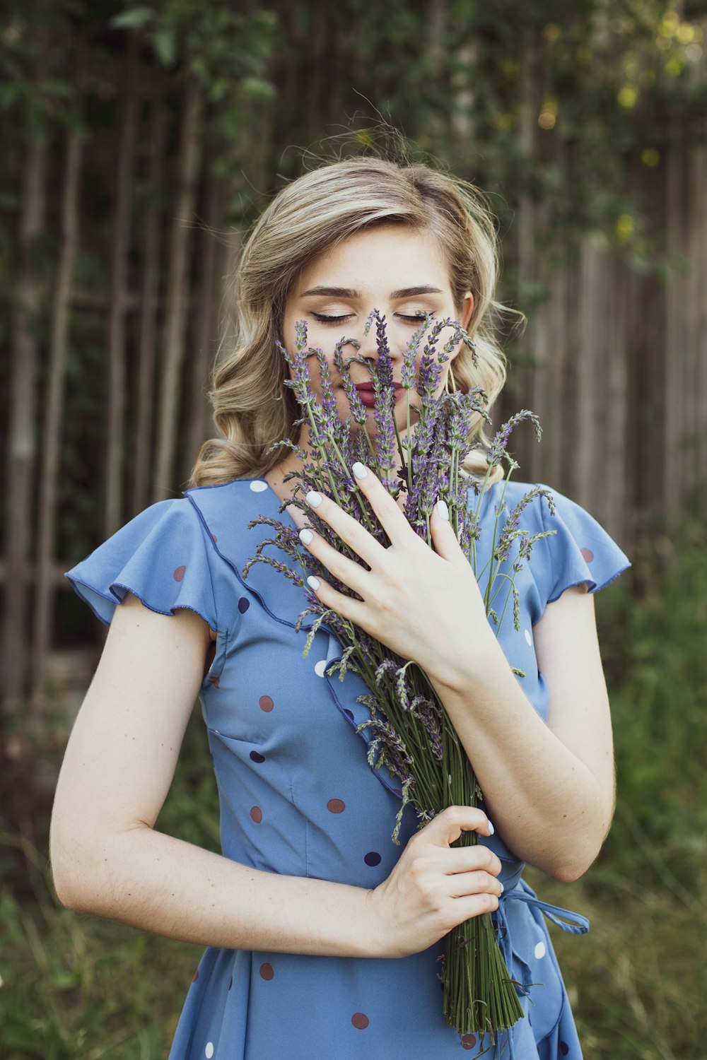 girl in blue crew neck t-shirt holding flowers