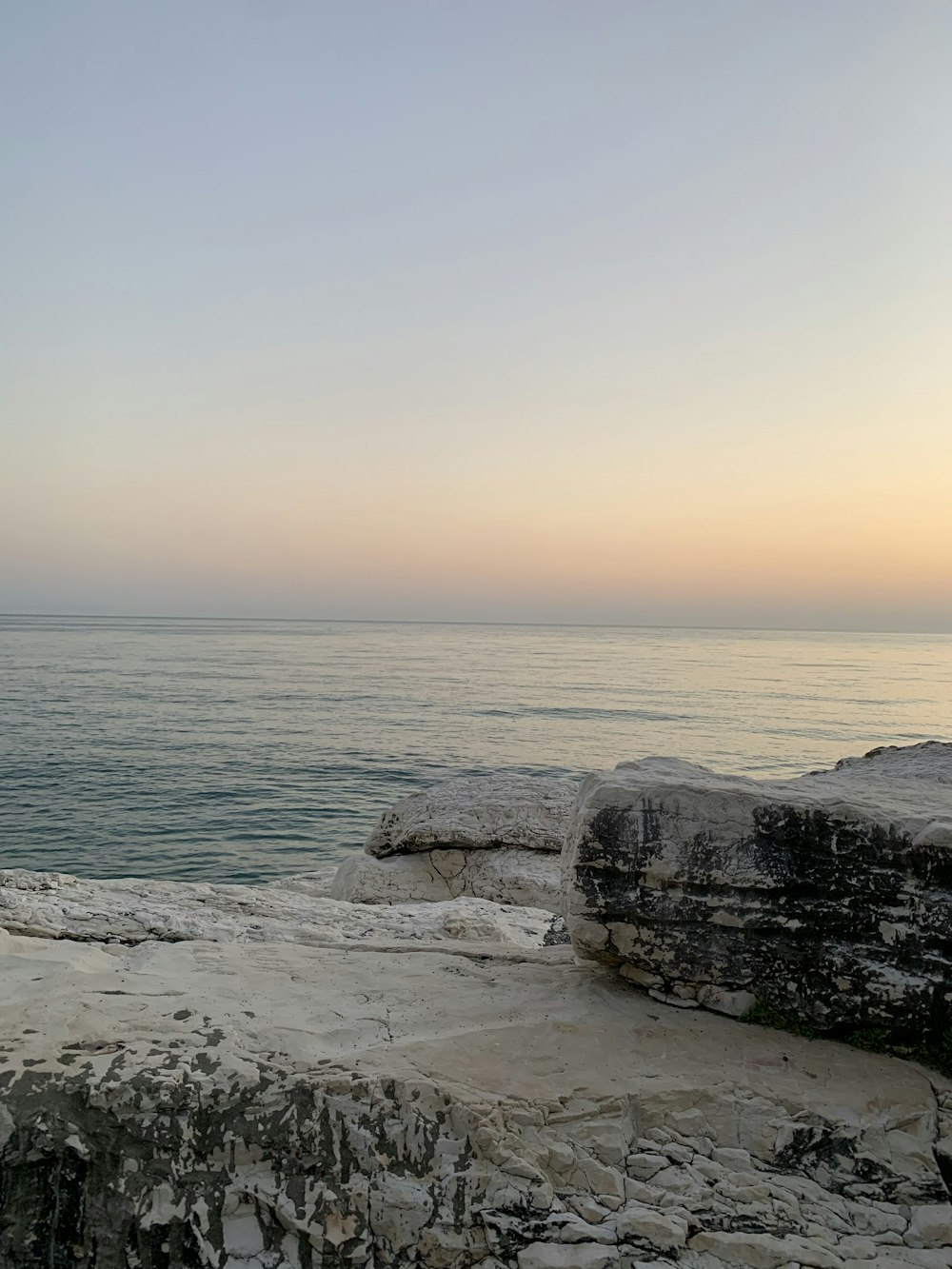 a bench sitting on the edge of a cliff overlooking the ocean