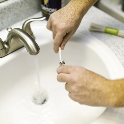 Plumber repairing silver steel faucet