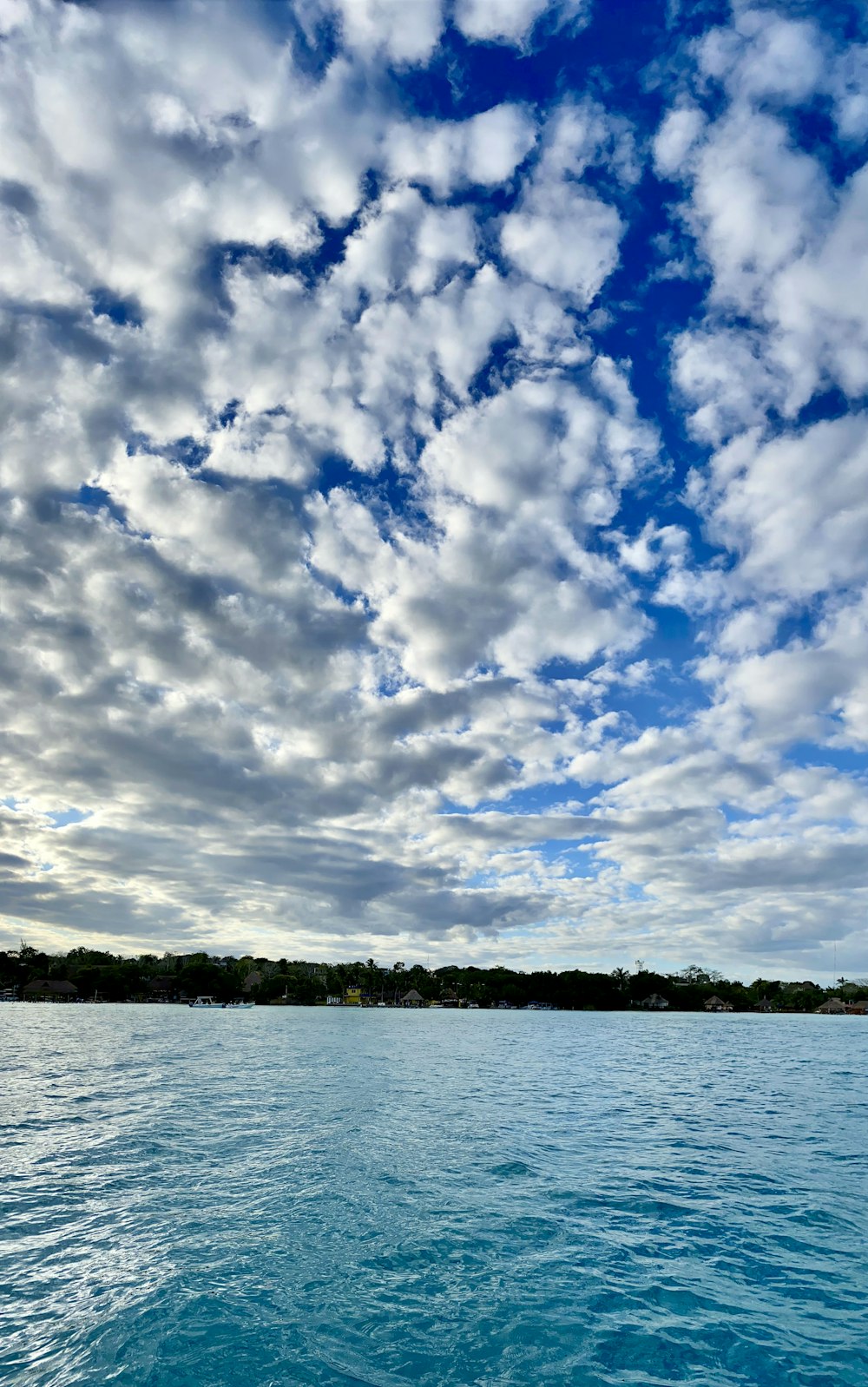 body of water under blue sky and white clouds during daytime