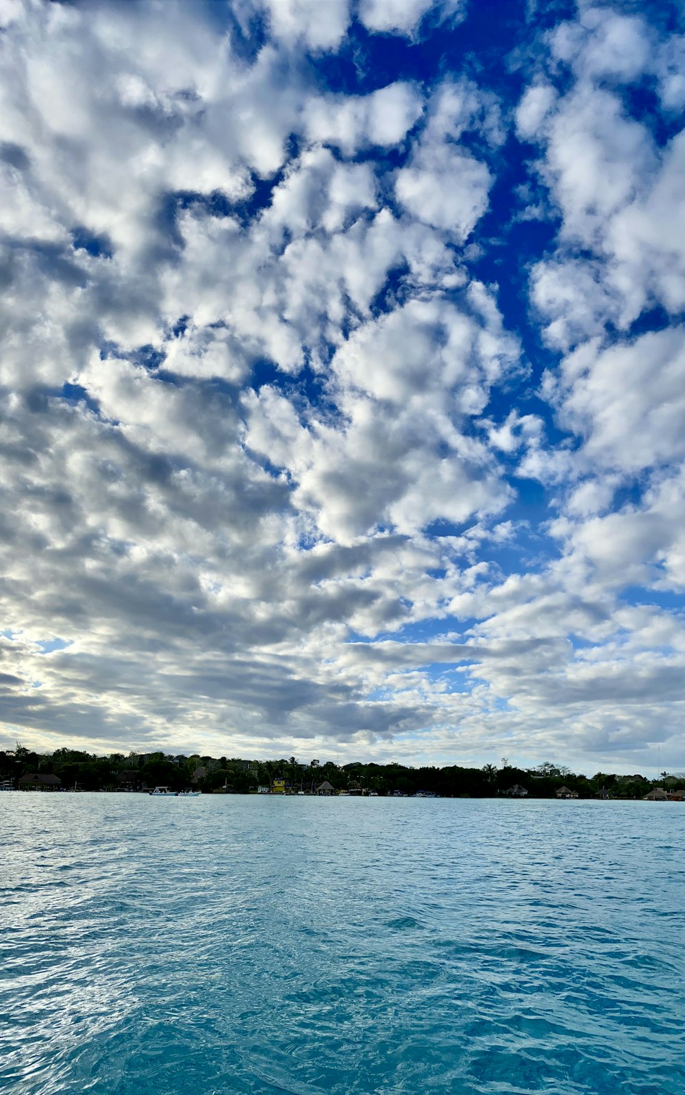Cuerpo de agua bajo el cielo azul y nubes blancas durante el día