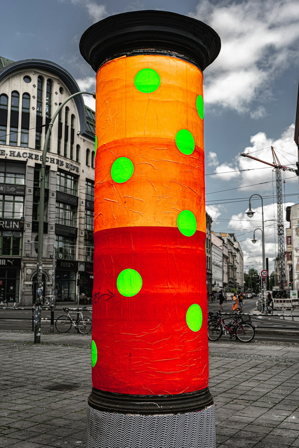 a large orange and green pole with green dots on it