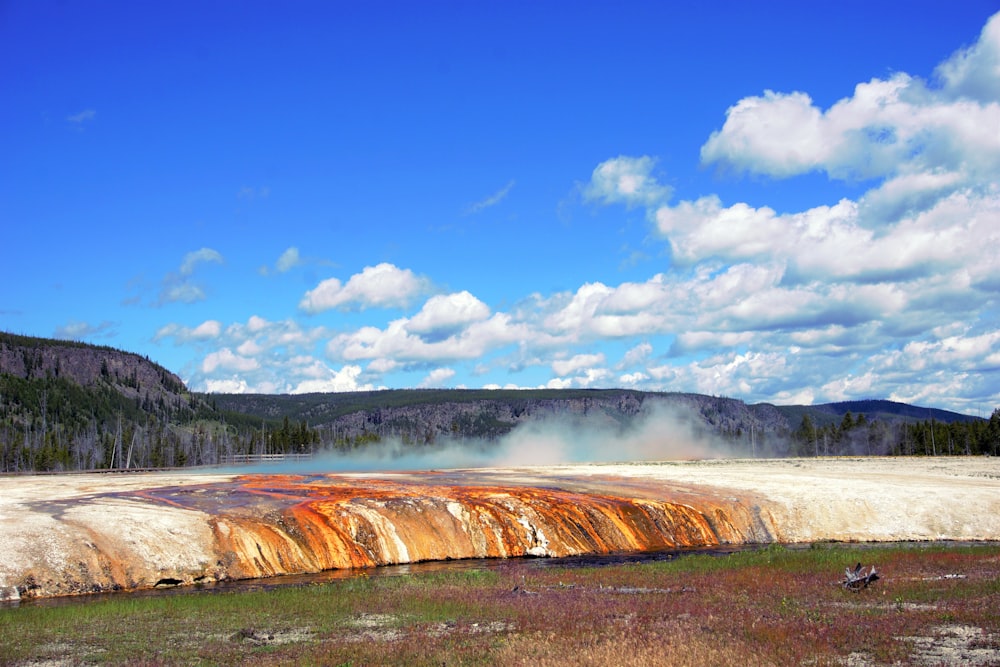 brown and white water falls under blue sky during daytime