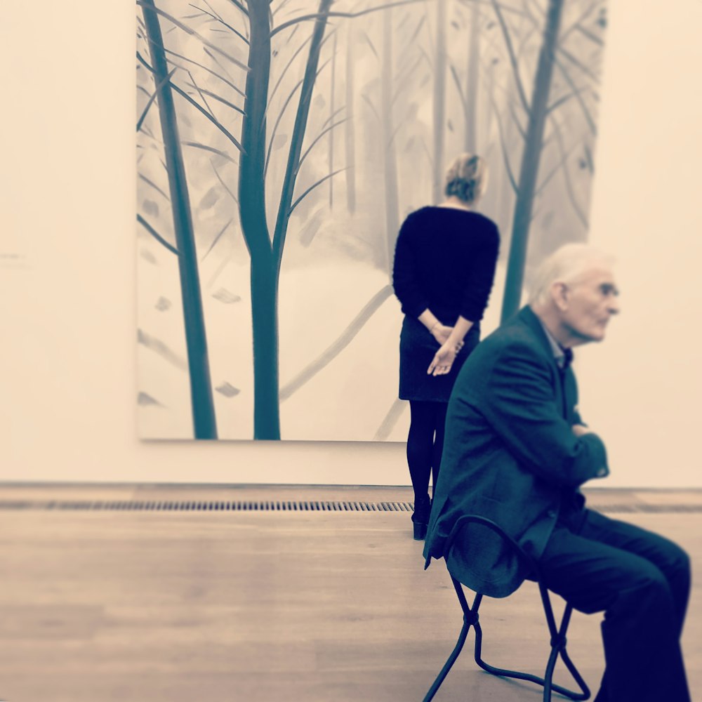 man in black suit sitting on chair