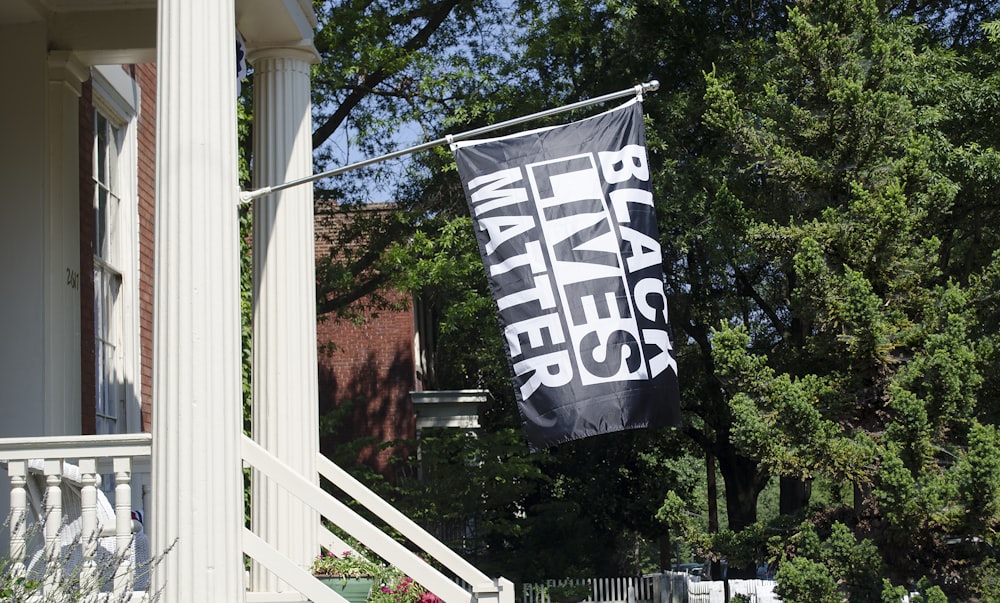 uma bandeira preta e branca pendurada ao lado de uma casa