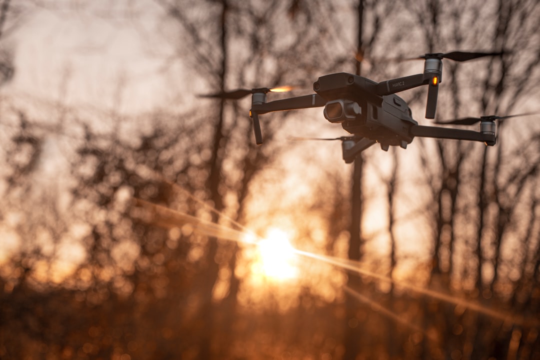 white drone flying during sunset