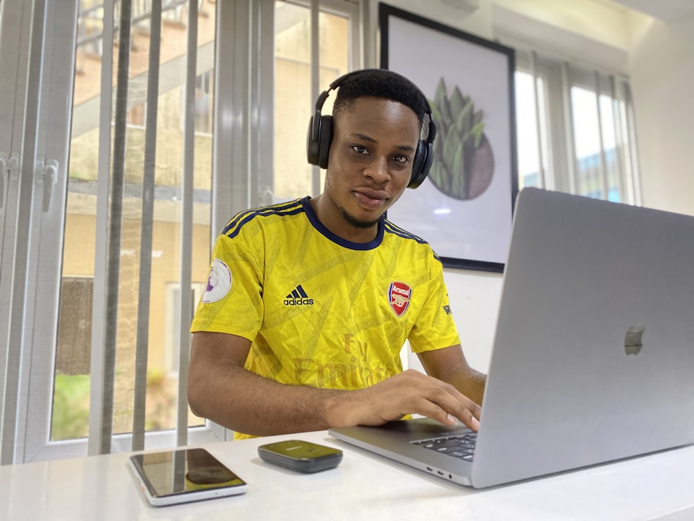 man in yellow and blue adidas crew neck t-shirt wearing black headphones