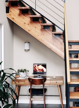 black flat screen tv turned on near brown wooden table