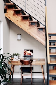 black flat screen tv turned on near brown wooden table