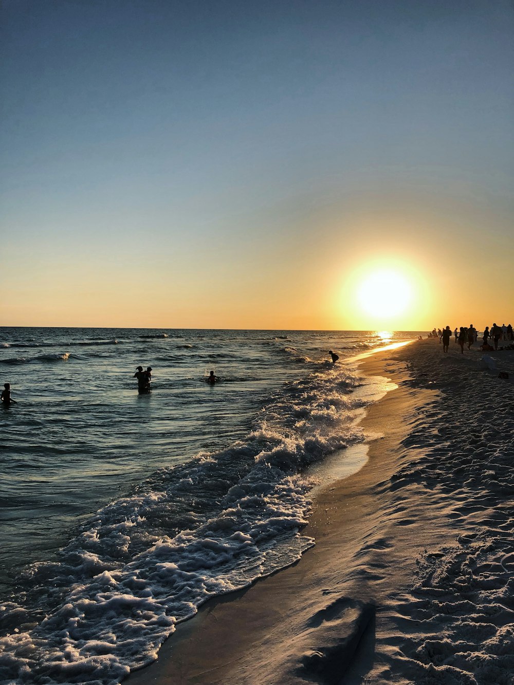 people on beach during sunset