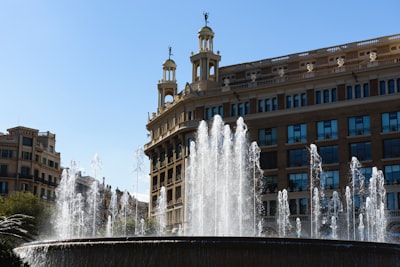 water fountain in front of brown concrete building during daytime