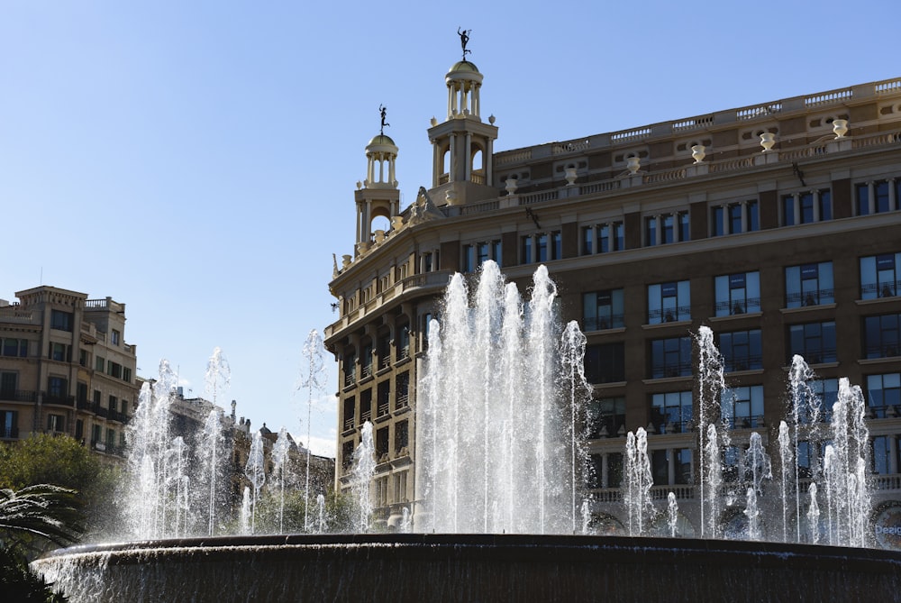 fonte de água em frente ao edifício de concreto marrom durante o dia