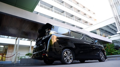 A sleek black car waiting outside Los Angeles airport terminal